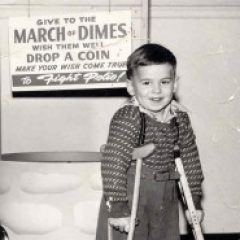 A black and white picture of myself as a five year old in front of the March of Dimes "fight polio" wishing well